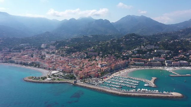 Menton aerial shot over the city harbor and Alps mountains in background Franco-Italian border