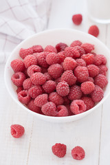 Common raspberries. Ripe red fruits in white bowl. View from above