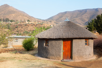 Traditional african round clay house with thatched roof in village, Kingdom of Lesotho, Southern...