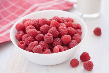 Common raspberries. Ripe red fruits in white bowl.