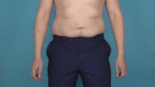 Man jumps, fat folds and overweight on the abdomen shaking in slow motion. Obesity, graceless body. Plump or thick guy who eats a lot of fatty fried foods and drinks beer. Male health, figure and diet