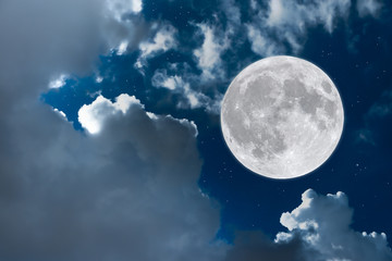 Full moon with white clouds in blue sky.