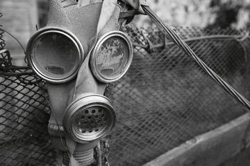 Old gas mask on a background of a metal grille fence. Nature conservation concept. - 282847288