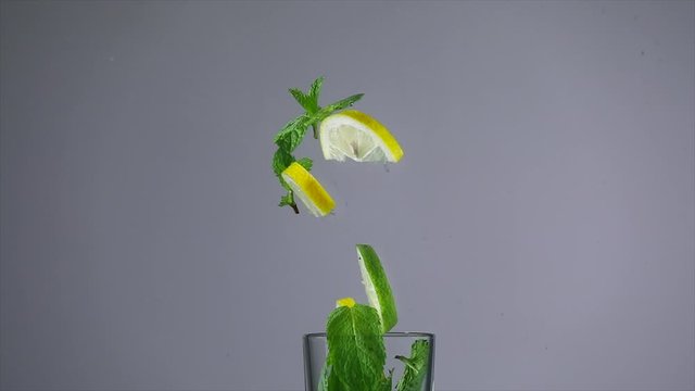 Fresh green mint and citrus fruits in water, slow motion