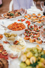 Different salad and snack and sandwitches on the white table. Stand-up meal olives, cheese, fruits.