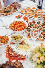 Different salad and snack and sandwitches on the white table. Stand-up meal olives, cheese, fruits.