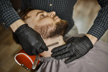 a guy doing a haircut and styling a beard 