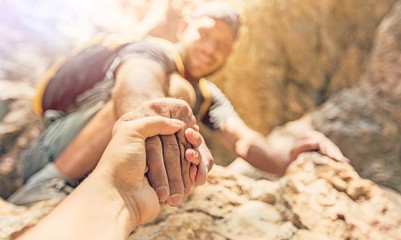 Adventurers helping each other to climb the mountain