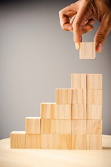 Wooden blocks stacked against grey background