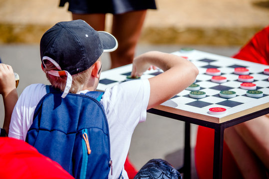 The boy plays checkers on the Playground.