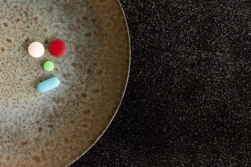 Colored pills or medications on a plate. Health concept. Copy space Legal drugs of the pharmaceutical industry.