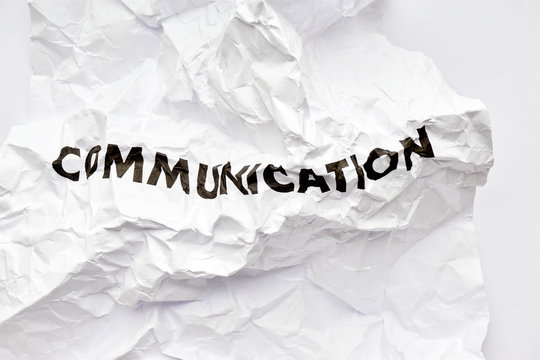 Crumpled white paper with the word communication printed in black. Concept of bad disrupted communication or miscommunication. Symmetrical shot with copy space.