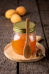Apricot Jam in a Glass Jar and Fresh Apricots on Wooden Background Tasty Homemade Jam Autumn Harvesting Vertical Wooden Cut Board and Wooden Spoon