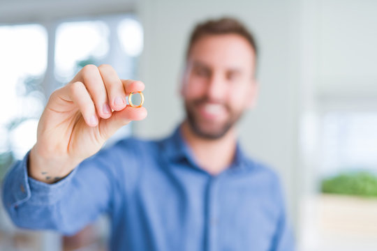 Close up of man hand holding alliance ring and smiling