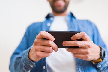 Close up of man hands using smartphone and smiling