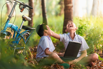 Two boys studying by online learning with laptop at outdoor,nature countryside of Thailand