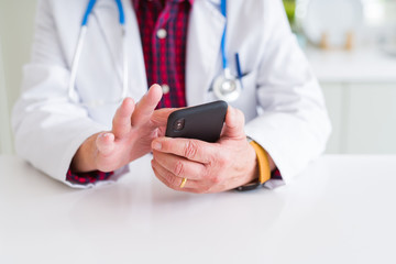 Close up of doctor man hands using smartphone and wearing stethoscope