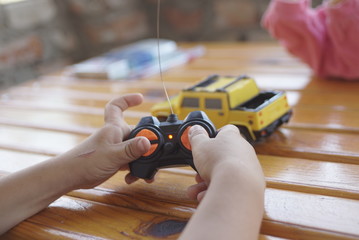 a boy playing with a car remote