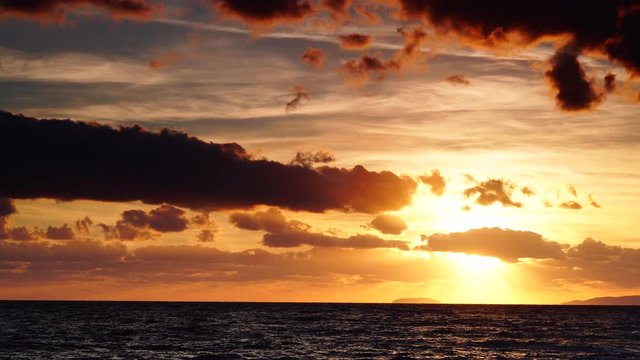 Dramatic sunset over sea surface with dark stormy clouds, Greece Peloponnese. Time lapse