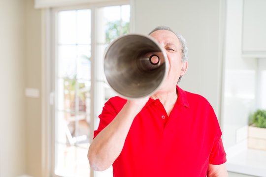 Senior man shouthing excited through vintage metal megaphone