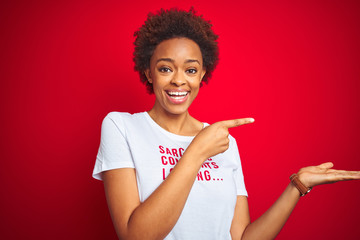 African american woman wearing sarcastic comments t-shirt over red isolated background amazed and...