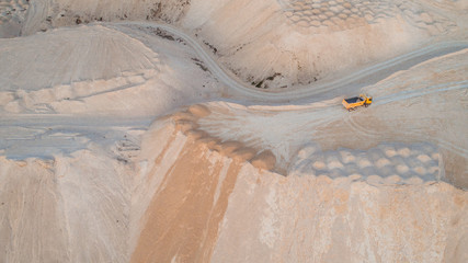 A truck on top of a quarry, aerial view.