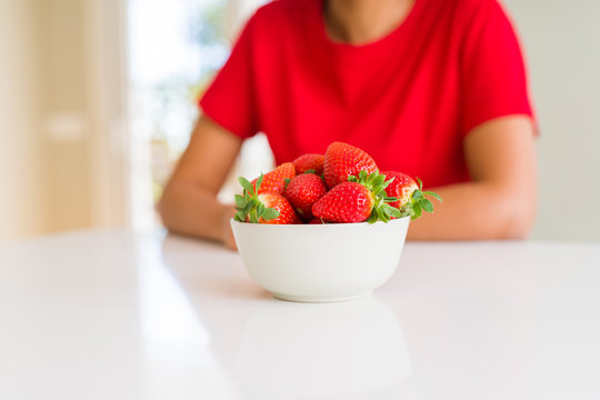 Close up of young woman eating fresh strawberries