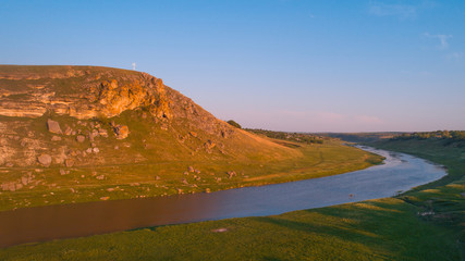 A beautiful river next to a cliff, shot from above.