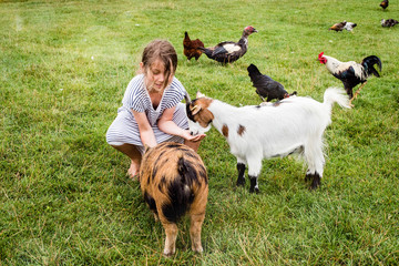 beautiful girl on holiday at the farm giving food to animals
