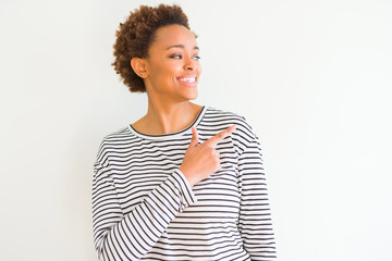 Young beautiful african american woman wearing stripes sweater over white background cheerful with a smile of face pointing with hand and finger up to the side with happy and natural expression 