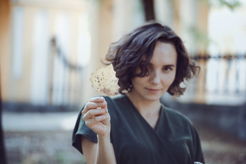 girl holds a yellow leaf