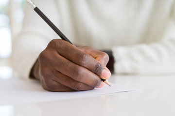 Close up of african man writing a note on a paper