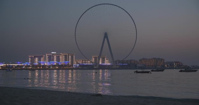 World tallest Ferris wheel in Dubaj at dawn, people walking