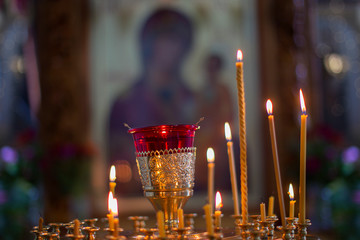 Church candles on the background of icons. Religion.
