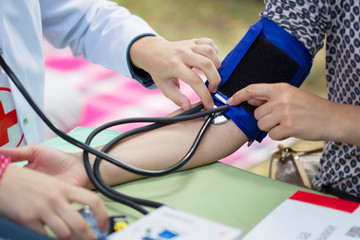 The doctor measures the pressure of the patient