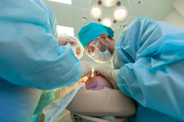 Baldness treatment. Hair transplant. Surgeons in the operating room carry out hair transplant...
