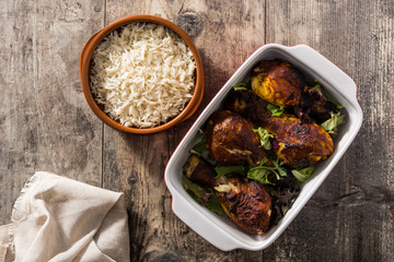 Roasted tandoori chicken with basmati rice on wooden table. Copyspace