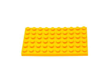 Yellow plastic building block isolated on white background. Developmental toys for children.