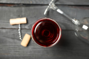 Flat lay composition with wine glasses, corkscrew and cork on wooden background, closeup