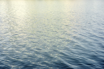 Water surface with ripples and sunlight reflections