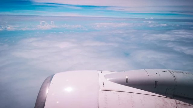Airplane flight. Wing of an airplane flying above the clouds with cloudy sky. View from the window of the plane. Airplane, Aircraft. Traveling by air. 4K UHD video
