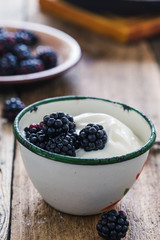 Morning meal, yogurt, fresh summer blackberries in rural mug