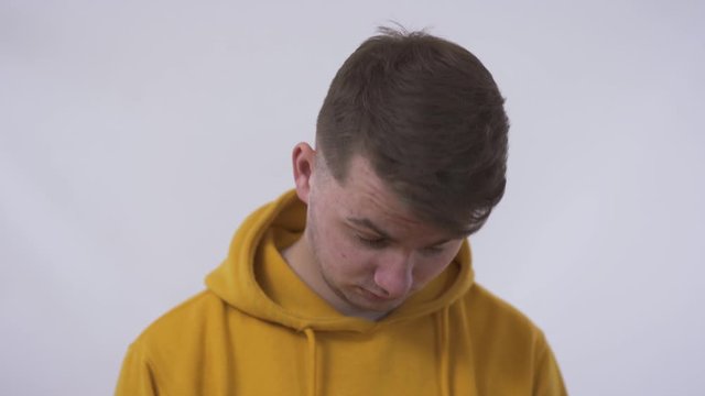 Closeup portrait, funny looking guy, shy sad young man, sign movement, feeling guilty, sorry for actions, faults did wrong. White background. Expression, emotion, reaction. Problem skin and acne.