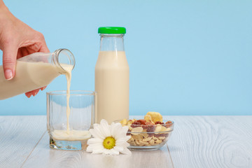 Woman's hand pouring milk into a glass.