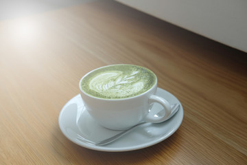 hot matcha green tea latte on wood table.