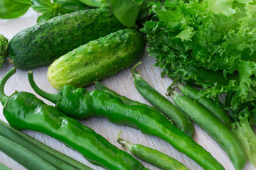 Healthy green vegetables: cucumbers, lettuce, onions and peppers.