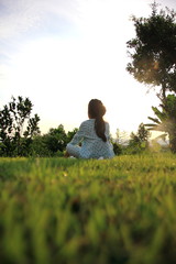 Child girls in pajamas come out to sit yoga on the grass in the morning.