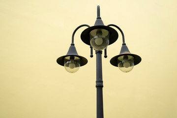 classic of three on one lamp pole with yellow background