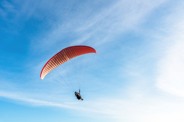 Paragliding Extreme sport, Paraglider flying on the blue sky and white cloud in Summer day at Phuket Sea, Thailand.