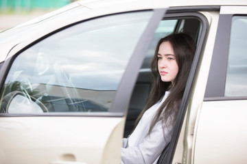 Young girl in the car. Beautiful woman driving